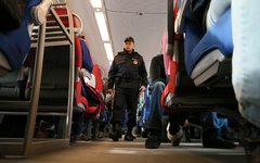 Сотрудник службы безопасности проверяет электропоезд «Ласточка» перед отправлени