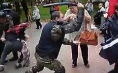 Омоновец избил женщину дубинкой. Кадр с видео на YouTube