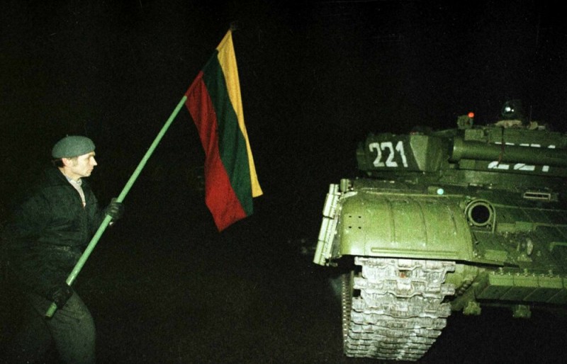 Один из протестующих с флагом около советского танка. Ночь 13 января 1991 года. Фото с сайта ru.wikipedia.org