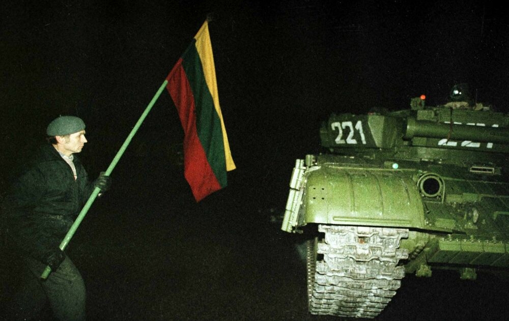 Один из протестующих с флагом около советского танка. Ночь 13 января 1991 года. Фото с сайта kam.lt Протестующий с флагом около советского танка
